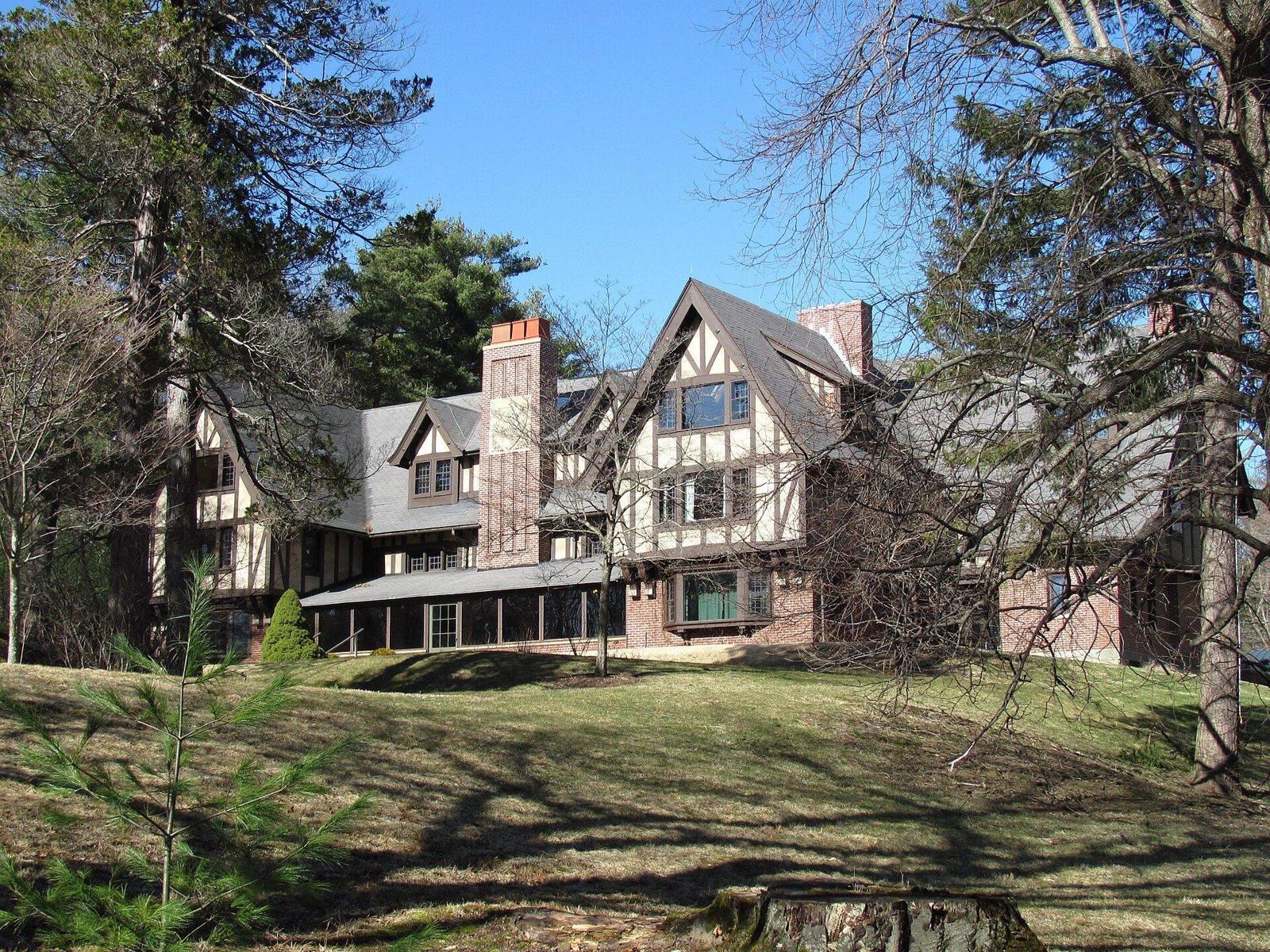 Henry Higginson House in Lincoln, Massachusetts, west of Boston: a half-timbered Tudor Revival house with steep gables and tall brick chimneys.