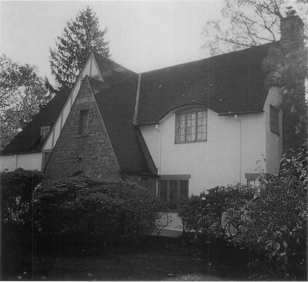 Black-and-white photograph of the Tudor Revival house at 9 Roxbury Road, Scarsdale, with a stone gable and steel casement windows.